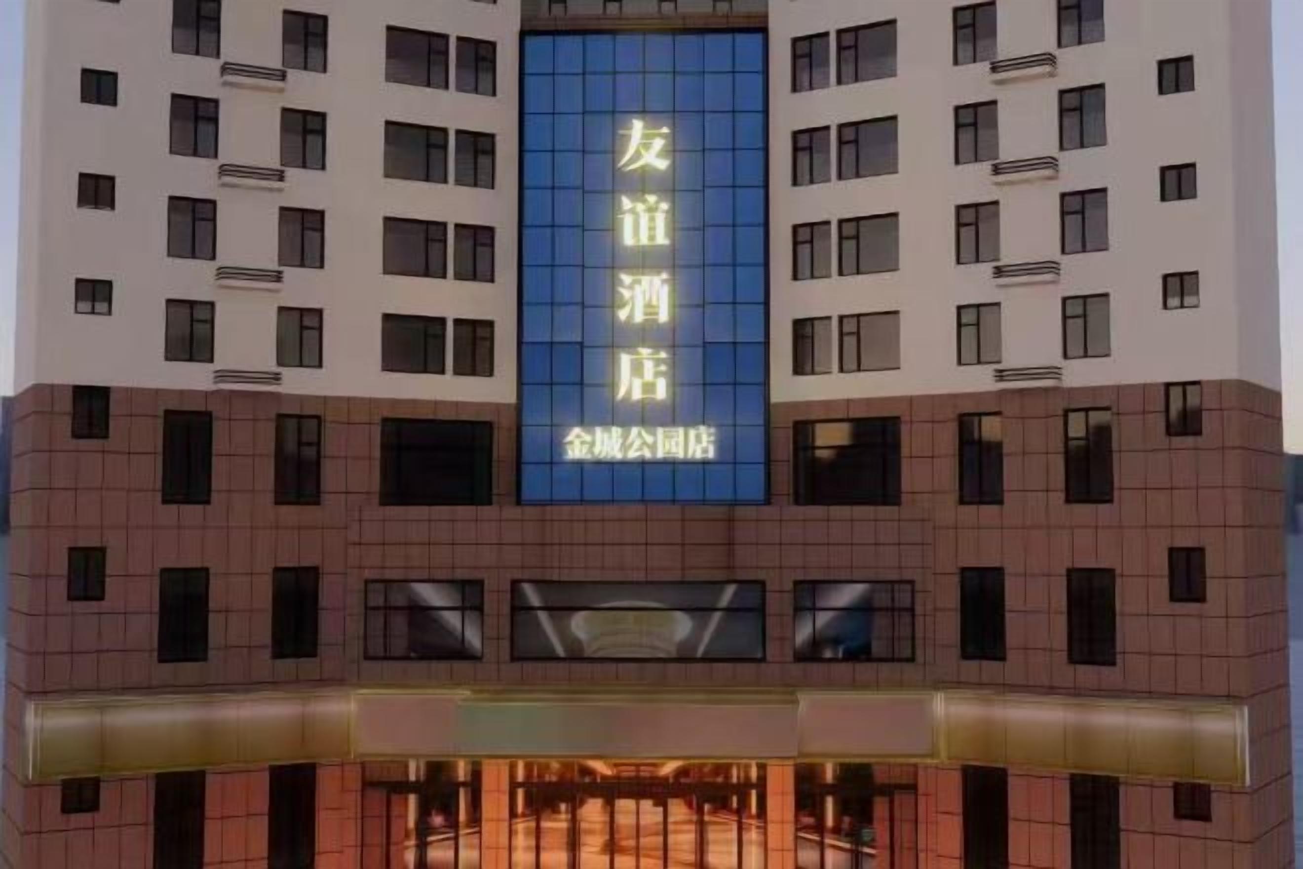 Un edificio de hotel con un llamativo letrero azul con caracteres chinos.