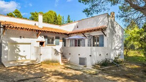 A white building with a tiled roof, a covered staircase, and a small garden area. - Stunning home in Fournès (Fournès)