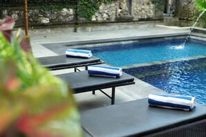 A swimming pool with lounge chairs and towels. - Warsa's Garden Bungalow and Spa (Bali)