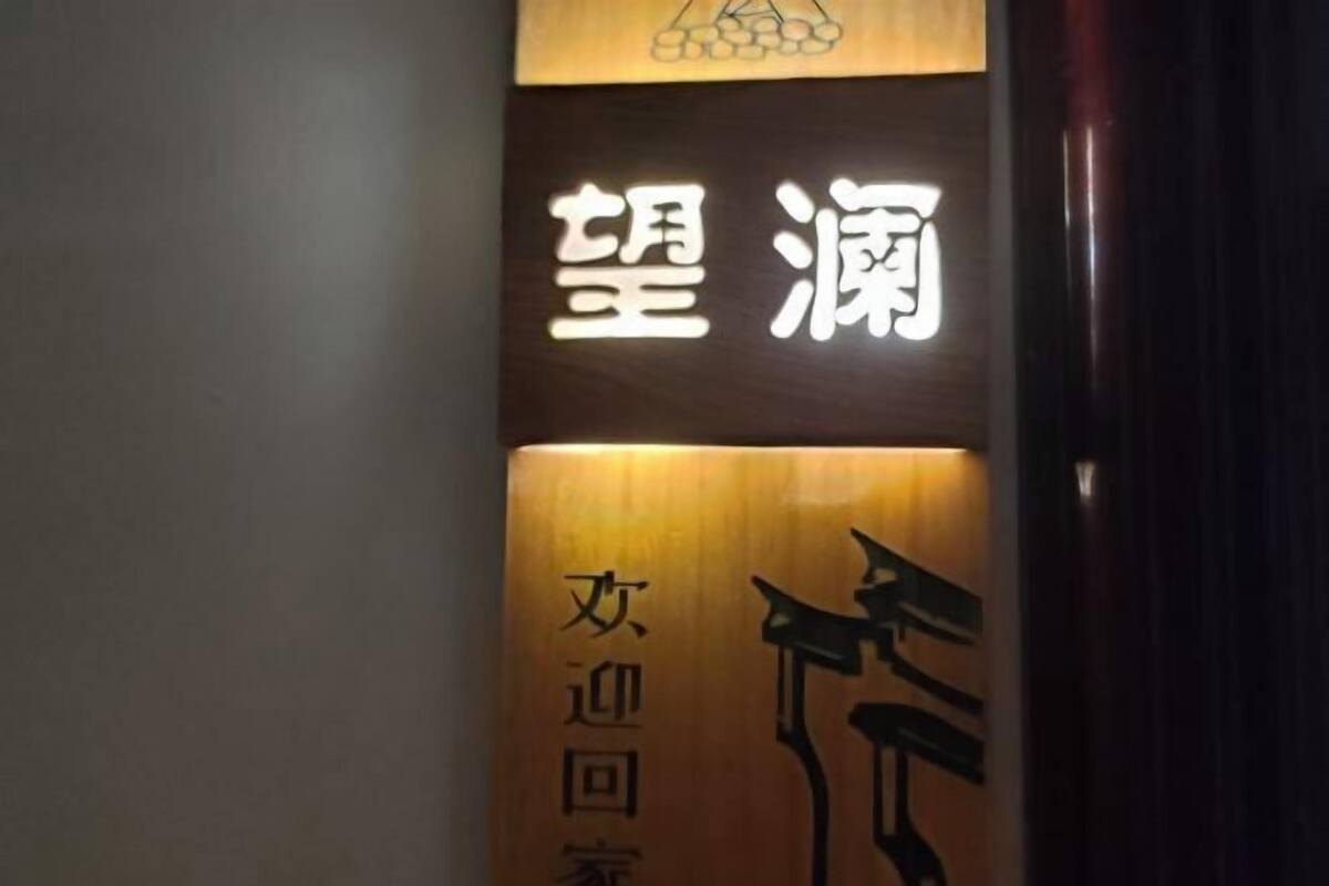 Ein Schild mit chinesischen Schriftzeichen, möglicherweise ein Hotelname oder Firmenname.