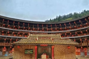 A traditional multi-tiered building with a central entrance and red lanterns.