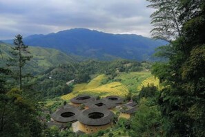 Un paysage montagneux caractérisé par des champs en terrasses et des bâtiments traditionnels à toits arrondis.