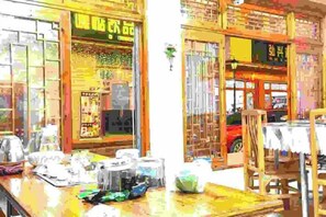 A storefront with a sign in a foreign language, a display counter with various items, and a red vehicle outside. - YunShuiYao Tian'e Hotel (Nanjing County)
