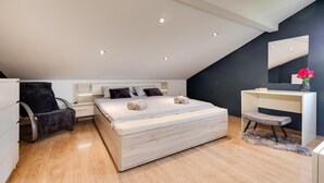 Un dormitorio moderno con una cama grande, un escritorio y una silla.