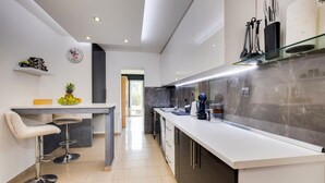 Una cocina moderna con una encimera amplia, una cafetera y un frutero.
