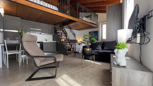 A modern living room with a high ceiling, a staircase, a dining area, and a kitchen. - Medieval IV - Historic Experience in Como (Como)