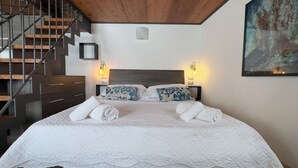 A bedroom with a bed, two bedside lamps, a wooden headboard, a staircase, and a painting on the wall. - Medieval IV - Historic Experience in Como (Como)
