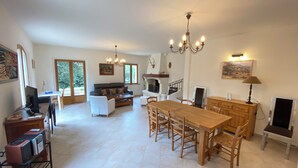 A spacious living area with a dining table, sofas, and a fireplace. - 06CB : Pretty country house for 8 (Tourrettes-sur-Loup)