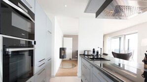 Una cocina moderna con electrodomésticos de acero inoxidable, un ventanal y vistas al exterior.