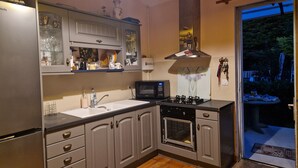 Une cuisine équipée d’un four à micro-ondes, d’une cuisinière et de placards.