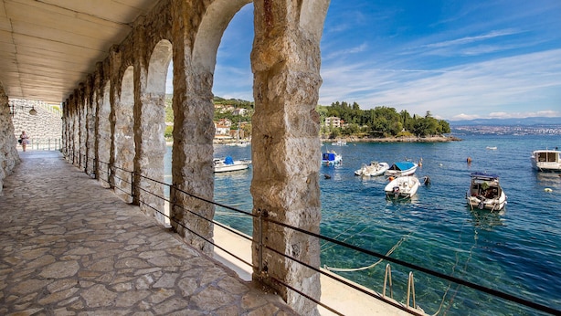 A stone-paved walkway with arches, a clear blue sky, and boats on a calm sea. - 1 bedroom lovely apartment in Ika (Ika)