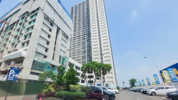 A multi-story building with a modern architectural design, featuring a mix of glass and concrete elements. - Warm And Homey Studio At Sky House Alam Sutera Apartment (Tangerang)