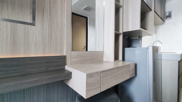 A modern kitchen with a built-in countertop, a refrigerator, and a sink. - Cozy Living Studio The Alton Apartment (Semarang)