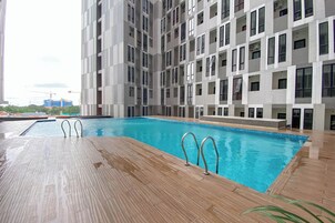 Un edificio moderno con piscina y terraza de madera.