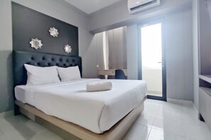 Ett modernt hotellrum med en stor säng, en mörk sänggavel och dekorativa väggspeglar.