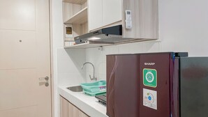 A kitchen with a built-in microwave, a sink, and a Sharp refrigerator. - Serene Living Studio Tokyo Riverside Pik 2 Apartment (Teluknaga)
