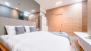Et moderne hotelværelse med en stor seng, indbygget skab og separat badeværelsesområde.