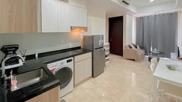 Apartemen Deluks | Dapur pribadi | Lemari es besar, kompor, ketel listrik, dan meja makan