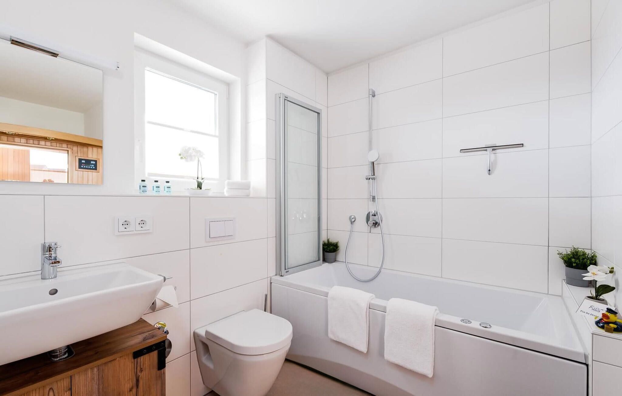 A modern bathroom with a sink, toilet, and shower area.