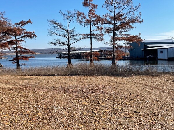 Una propiedad junto al lago con muelle, un edificio de techo metálico y árboles con hojas otoñales.