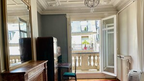 A room with a red carpet, a wooden cabinet, a radiator, and a balcony with a view of buildings. - Haussmann Opera Penthouse130M2 Exclusive full 4floors Stone Balcony (4 bedrooms)  (Paris)