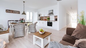 Um apartamento moderno com área de jantar, cozinha e sala de estar.