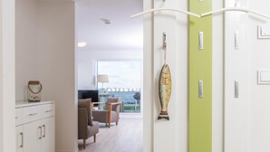 Et moderne hotelværelse med havudsigt, et spiseområde med bord og stole, og et tekøkken med skabe og et køleskab.