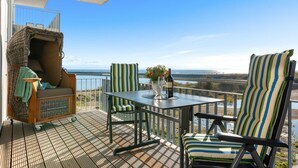 Un balcon avec une table, des chaises et un canapé.