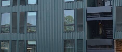 En modern byggnad med ett platt tak, stora fönster och en centralt placerad trappa.