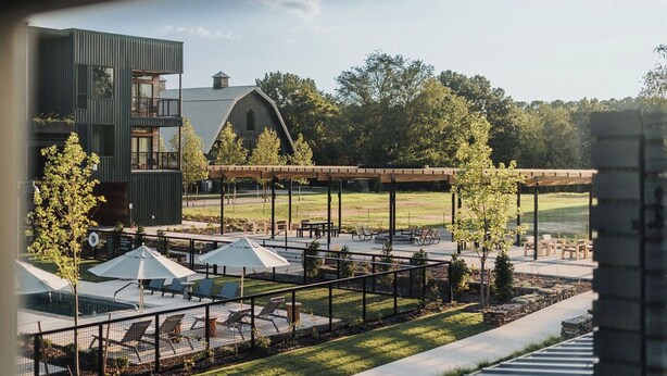 A modern building with a rooftop pool and outdoor seating area. - Stonebreaker Hotel (Fayetteville)