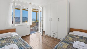 Ein Schlafzimmer mit zwei Betten, einem Kleiderschrank und einem Balkon mit Blick.