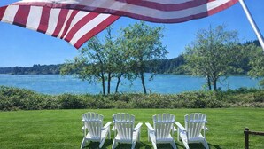 Een terras met witte stoelen en een grote Amerikaanse vlag.
