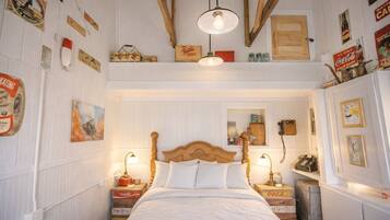 Quarto com cama de madeira, duas mesas de cabeceira, luminária pendente e decoração vintage.