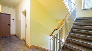 A staircase with a wooden handrail and metal balusters, leading to an upper floor.