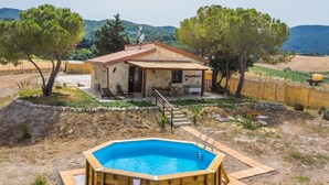 A rustic stone house with a wooden deck, a swimming pool, and a mountainous backdrop. - Casaletto Anticaluce by Interhome (Pastina)