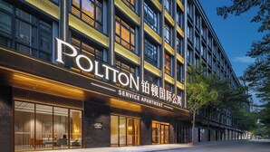 A modern building with a large sign reading "POLITON SERVICE APARTMENT". - Platinum International Apartments (Huiyang High speed Railway Station Xinghe COCO Store) (Huizhou)