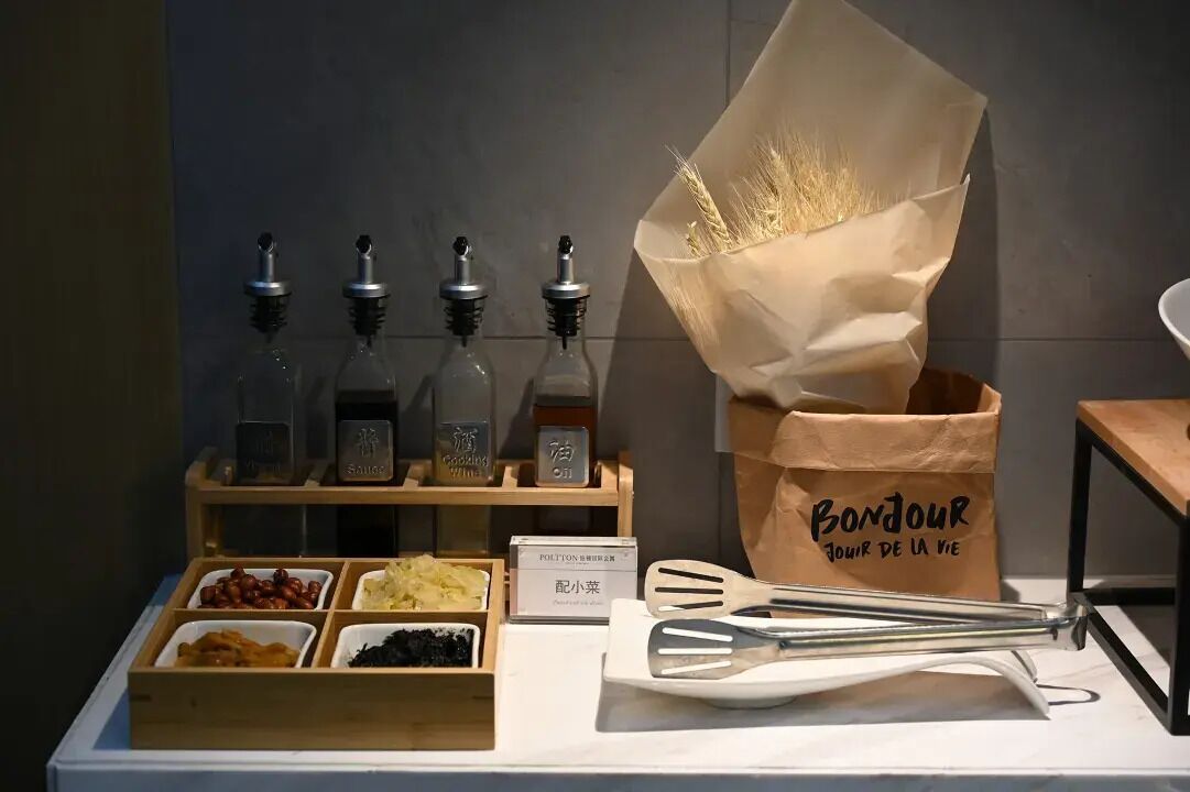 Een etalage met diverse kruiden en een papieren zak met de tekst 'Bonjour'.