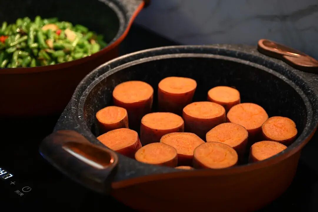 A cooking pot with sliced carrots.