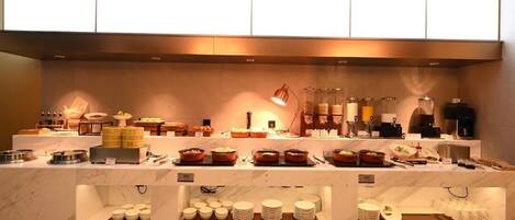 Una mesa de buffet con diferentes platos y utensilios.