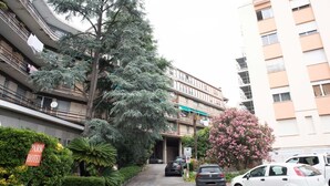 A multi-story residential building with balconies, a parking area, and a sign for a park hotel. - A 7 MIN A PIEDI DAL MARE, 5 DAL CENTRO, ZONA TRANQUILLA E POSTO AUTO PRIVATO (albisola superiore)
