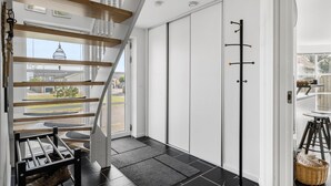 Ein modernes Interieur mit Treppe, Schiebetür und Blick ins Freie.