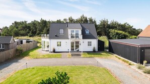 Ein zweistöckiges Haus mit Ziegeldach, einem Balkon und einer Haustür.