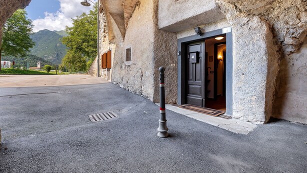 Un edificio de piedra con una puerta y un bolardo al frente.
