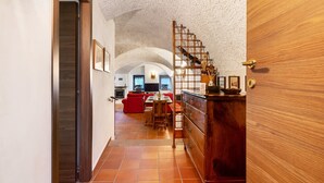 Un pasillo que conduce a un comedor con un sofá rojo, muebles de madera y una escalera.