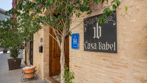 A building with a sign reading 'Casa Babel,' a potted tree, and a blue sign with 'H' and 'Superhotele' visible.