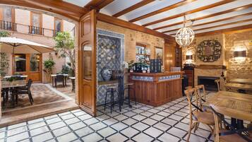 Un espacio amplio con zona de bar, mesas de comedor y suelo de baldosas.