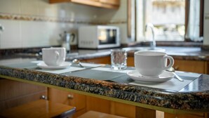 A kitchen with granite countertops, a microwave, and a window with a view.