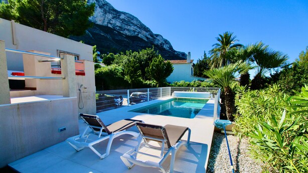 A pool area with lounge chairs, a pool, and a mountain backdrop. - Holiday Home 'Villa Betty' with Sea View, Wi-Fi and Air Conditioning (Dénia)