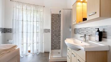 Une salle de bain moderne équipée d’une douche, d’un lavabo et de toilettes.