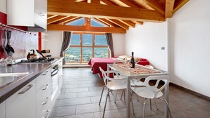 Une cuisine équipée d’une cuisinière, d’un évier et d’un coin repas avec des chaises et une table.